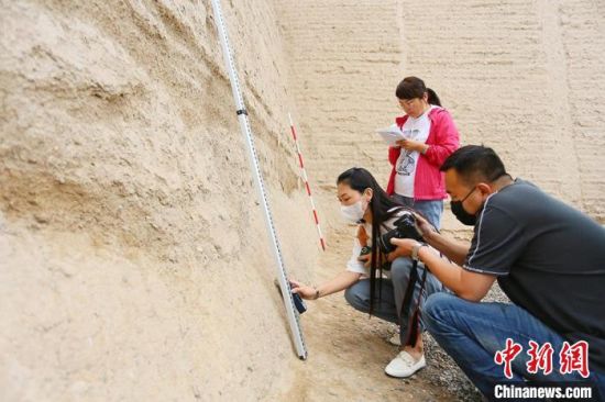 科技保護讓長城價值的真實性和完整性得到有效延續(xù)和傳承。圖為文物工作者正在測量關城的相關數據?！「哒?攝
