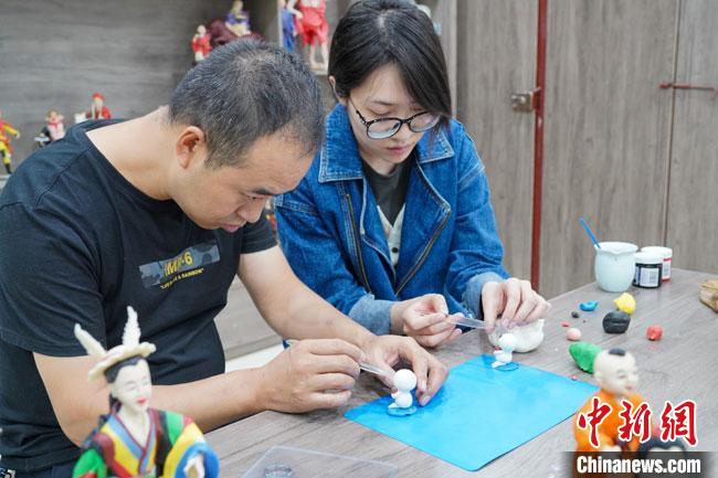 <a target='_blank'  data-cke-saved- >中新社</a>記者(右)現(xiàn)場(chǎng)體驗(yàn)面塑制作過(guò)程?！￡悹?zhēng)強(qiáng) 攝