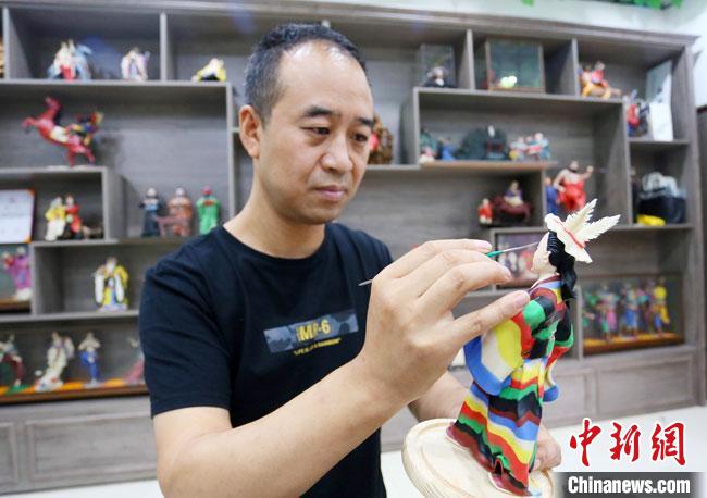 圖為安秋平正在創(chuàng)作代表隴南文縣民俗的《白馬人》作品。　高展 攝