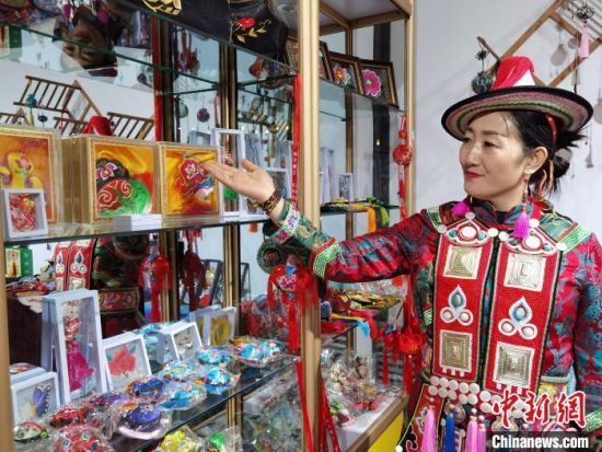 圖為身著民族服飾的隴原巧手展示手工藝品。(資料圖) 徐雪 攝