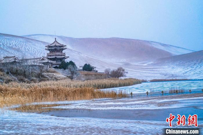 2021年11月28日，雪落鳴沙山月牙泉景區(qū)。　王斌銀 攝
