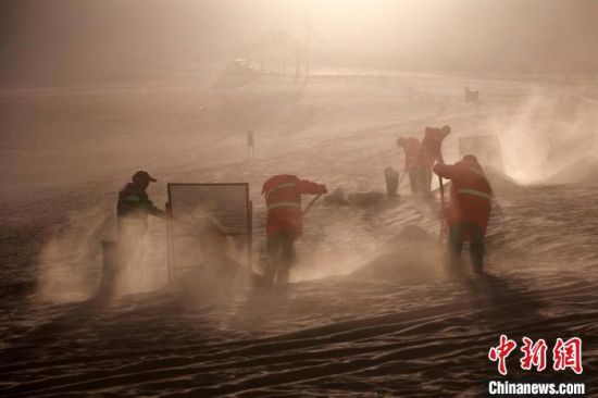 圖為敦煌市鳴沙山月牙泉景區(qū)“駱駝保姆”清理駱駝糞便?！垥粤?攝