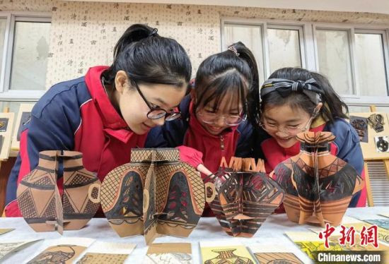 圖為學生用紙創(chuàng)作的立體彩陶?！⒂裉?攝