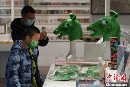 圖為“神馬來了”銅奔馬頭套吸引參觀者駐足?！【琶赖┰?攝