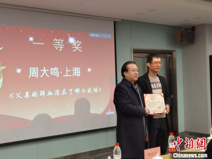 圖為作家、西北師范大學新聞與傳媒學院院長徐兆壽頒發(fā)一等獎證書，代領(lǐng)獎者上臺領(lǐng)獎。　楊娜 攝