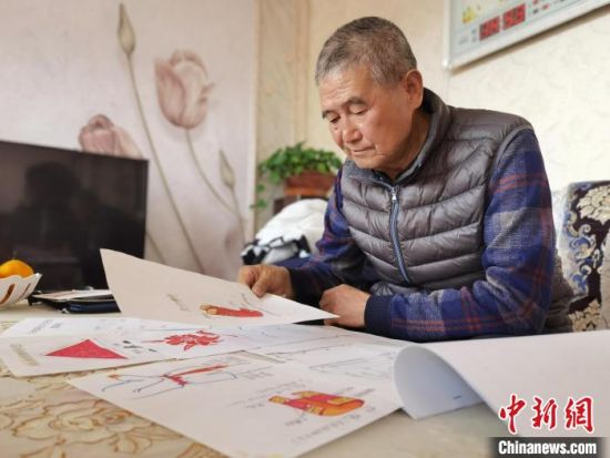 圖為陸鵬飛向記者展示多年帶隊(duì)的手寫筆記?！堟?攝