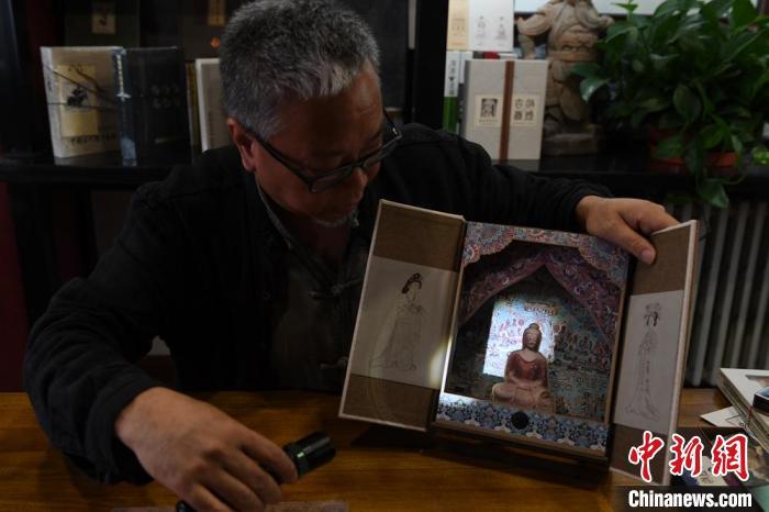 圖為讀者出版集團讀者晉林工作室獨立出品人徐晉林，展示互動性強的敦煌題材手工書。(資料圖) 楊艷敏 攝
