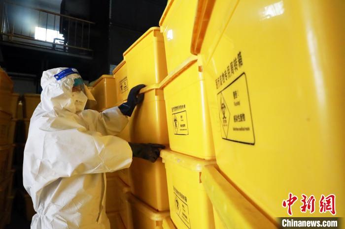 圖為工作人員搬運醫(yī)療廢物專用周轉箱。　魏建軍 攝