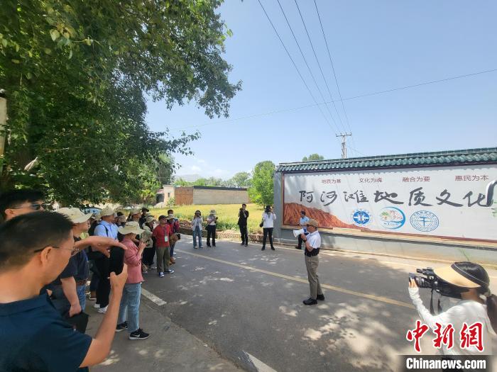 圖為中國地質(zhì)大學(北京)教授張緒教介紹村落情況?！『衍?攝