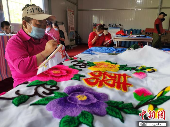 圖為婦女制作青繡?！?zhí)砀?攝