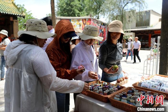 圖為民眾挑選手工藝產(chǎn)品?！⊙Φ?攝