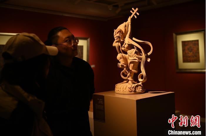 圖為季茂杰向參觀者介紹自己創(chuàng)作敦煌木雕的過程。李亞龍 攝</p>
<p>