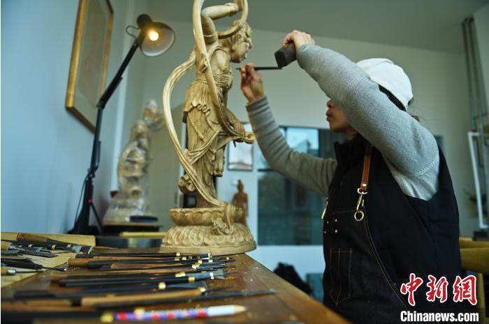 圖為季茂杰進行敦煌元素的木雕創(chuàng)作。李亞龍 攝</p>
<p>