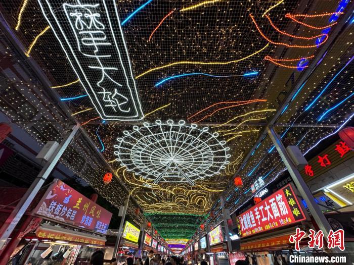 圖為明清街夜市燈光點(diǎn)亮具有武威文化元素的“摩天輪”彩燈?！〈魑牟?攝</p><p>