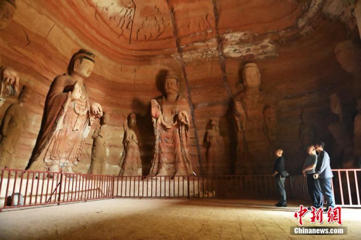 7月15日，游人參觀甘肅省平?jīng)鍪袥艽h百里石窟長廊中的南石窟寺1號窟。百里石窟長廊位于涇川縣境內(nèi)，由512個(gè)石窟、5眼窟中石井組成，現(xiàn)存王母宮石窟、鳳凰山石窟、南石窟寺、丈八寺石窟、羅漢洞石窟、太山寺石窟等規(guī)模較大的石窟群，還有數(shù)量眾多的小石窟群。南石窟寺開鑿于北魏永平三年，其中1號窟屬于大型七佛窟，七佛高達(dá)6米。中新社記者 李亞龍 攝