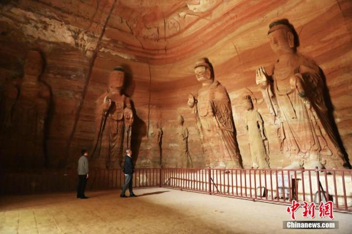 7月15日，游人參觀甘肅省平?jīng)鍪袥艽h百里石窟長廊中的南石窟寺1號窟。百里石窟長廊位于涇川縣境內(nèi)，由512個(gè)石窟、5眼窟中石井組成，現(xiàn)存王母宮石窟、鳳凰山石窟、南石窟寺、丈八寺石窟、羅漢洞石窟、太山寺石窟等規(guī)模較大的石窟群，還有數(shù)量眾多的小石窟群。南石窟寺開鑿于北魏永平三年，其中1號窟屬于大型七佛窟，七佛高達(dá)6米。中新社記者 李亞龍 攝