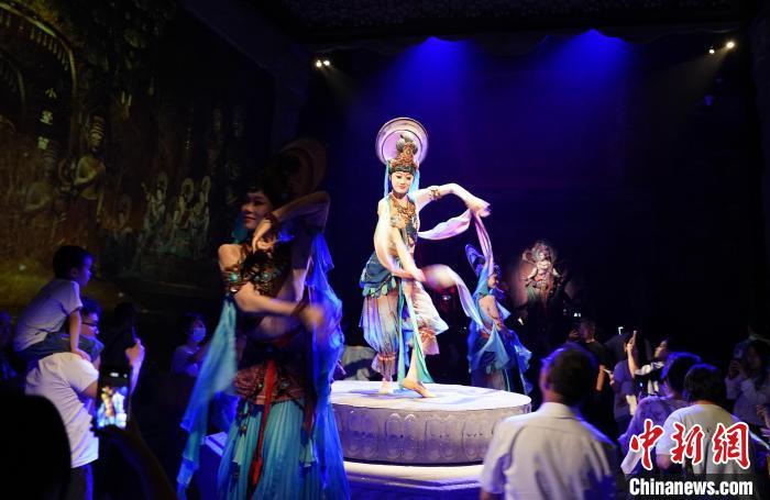 《樂動(dòng)敦煌》是全球首部洞窟式沉浸體驗(yàn)劇，利用真人與數(shù)字影像虛實(shí)交換實(shí)現(xiàn)沉浸式體驗(yàn)。圖為2023年8月28日晚，《樂動(dòng)敦煌》演出。(資料圖)中新社記者 毛建軍 攝