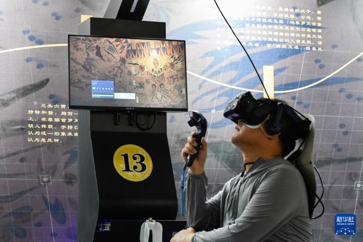 7月22日，游客借助VR設(shè)備沉浸式游覽莫高窟第285窟虛擬場(chǎng)景。新華社記者 郎兵兵 攝